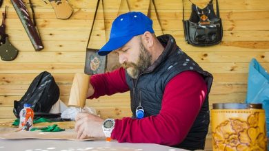 גבר דופק מסמר בפטיש עץ בישיבה